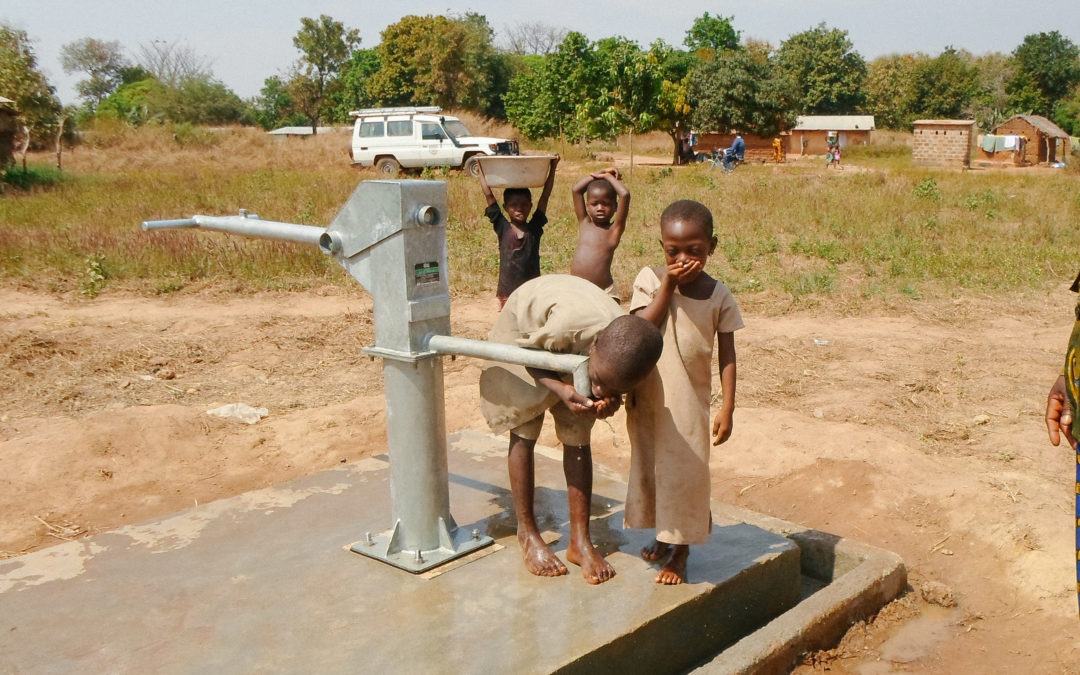 Children in Rural Togo at a water well taking a drink