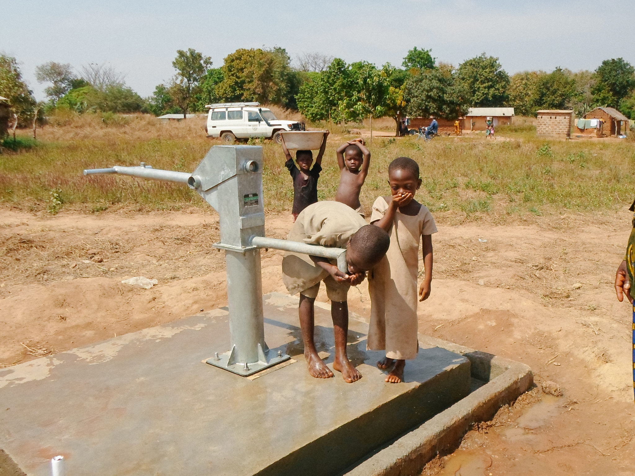 Children in Rural Togo at a water well taking a drink